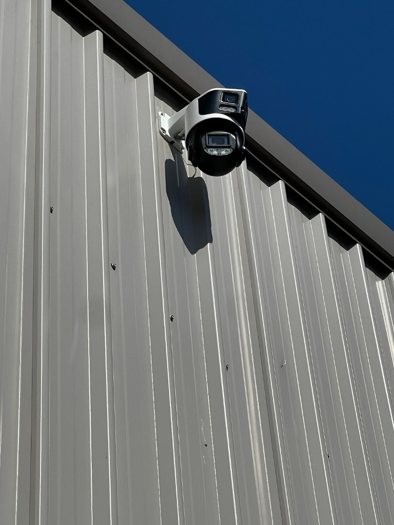 Dual-lens camera mounted high on a shed wall