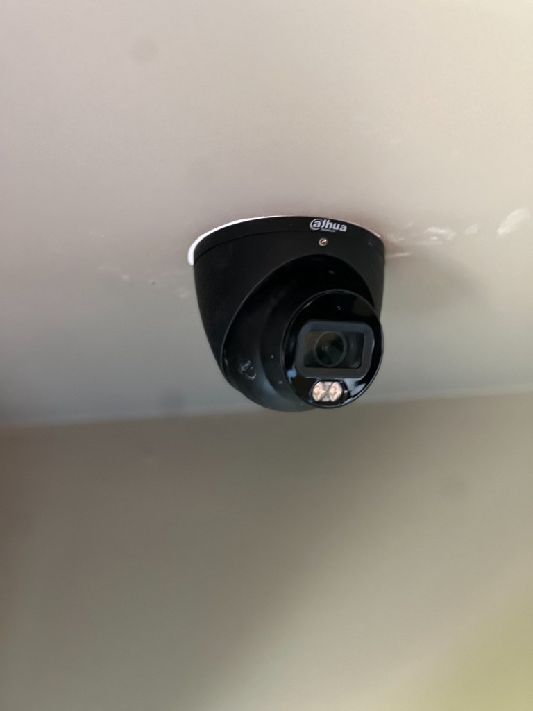 Black dome camera installed on an interior ceiling